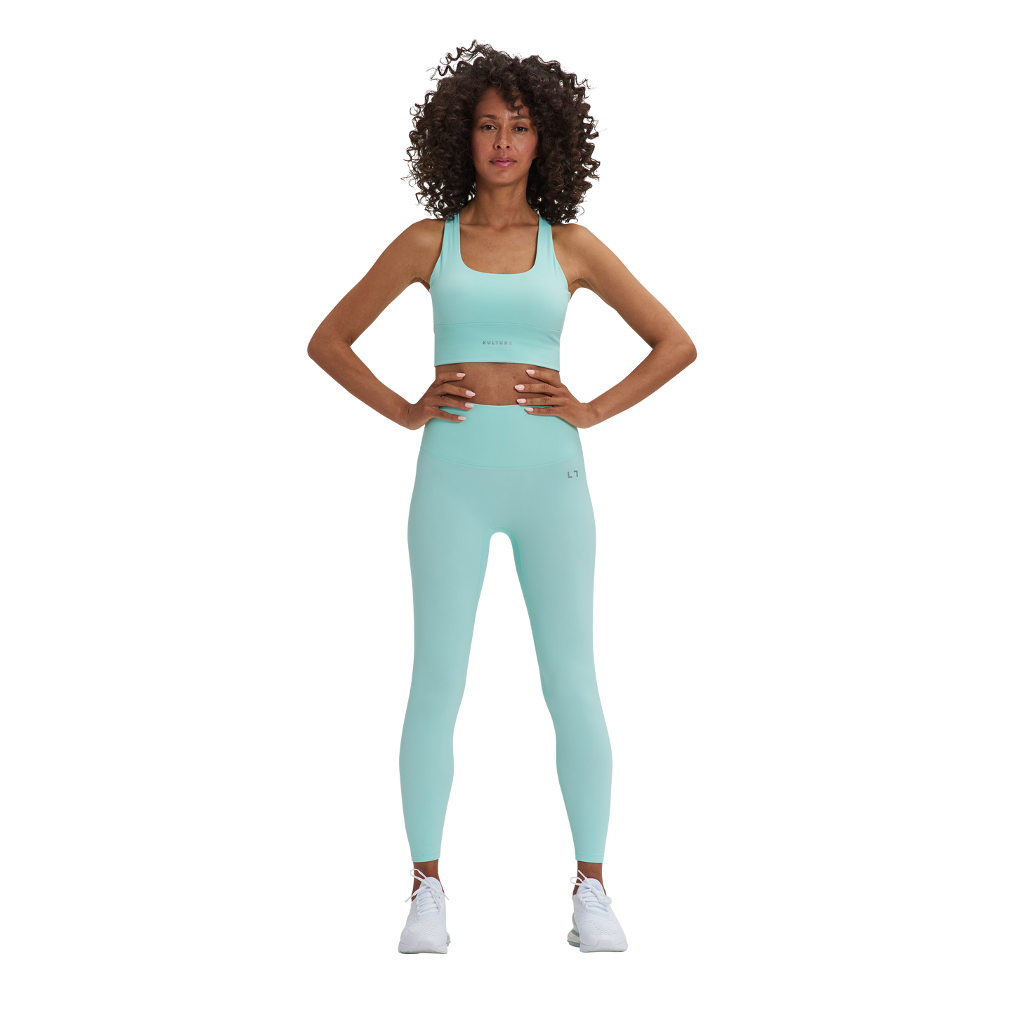A woman in a blue Kulture sports bra top and Soho Sculpt leggings.
