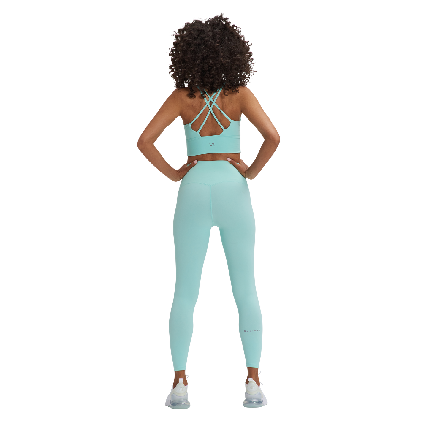 A woman in a blue Kulture sports bra top and Soho Sculpt leggings.