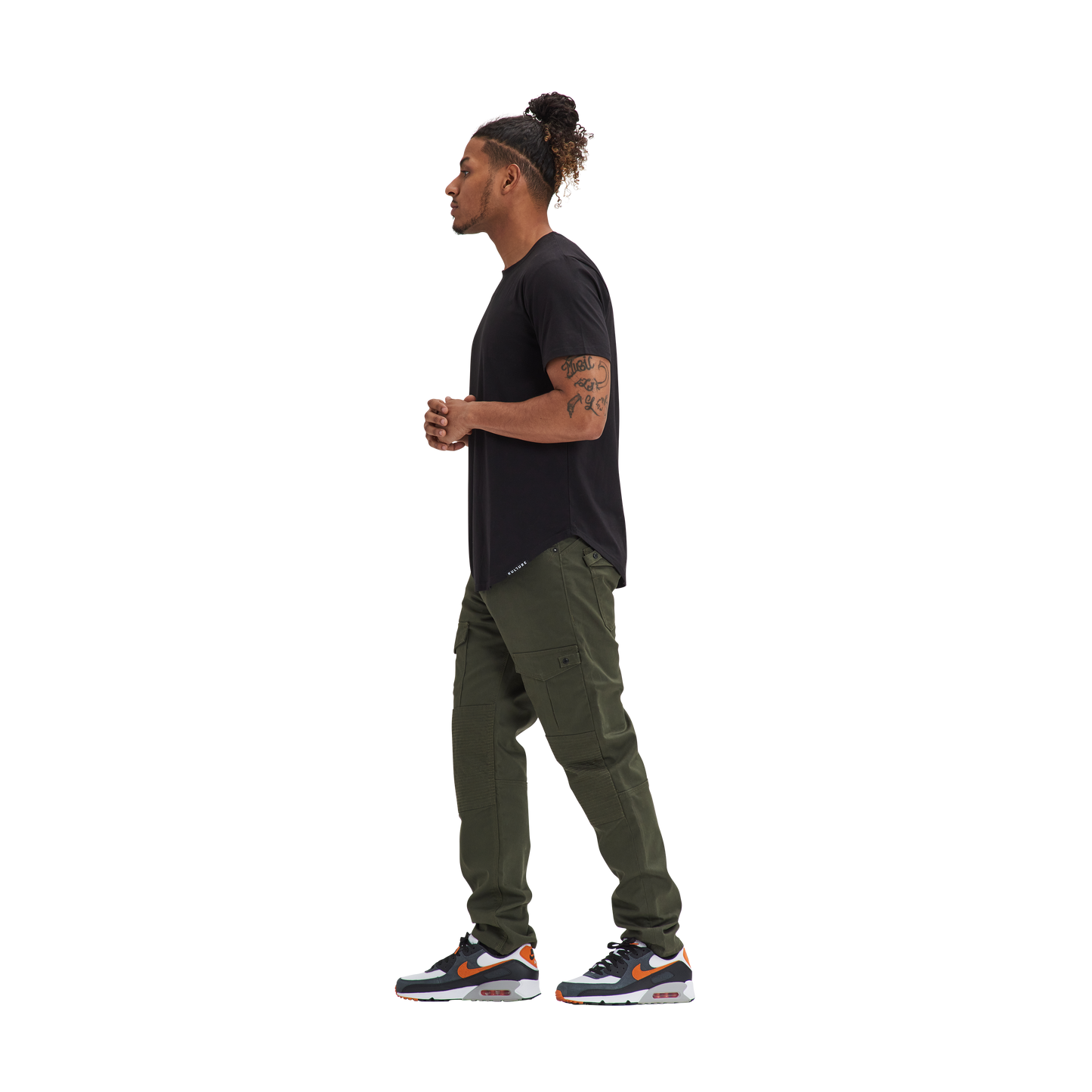 A man in a Kulture LAS Black Scoop Tee and green pants.