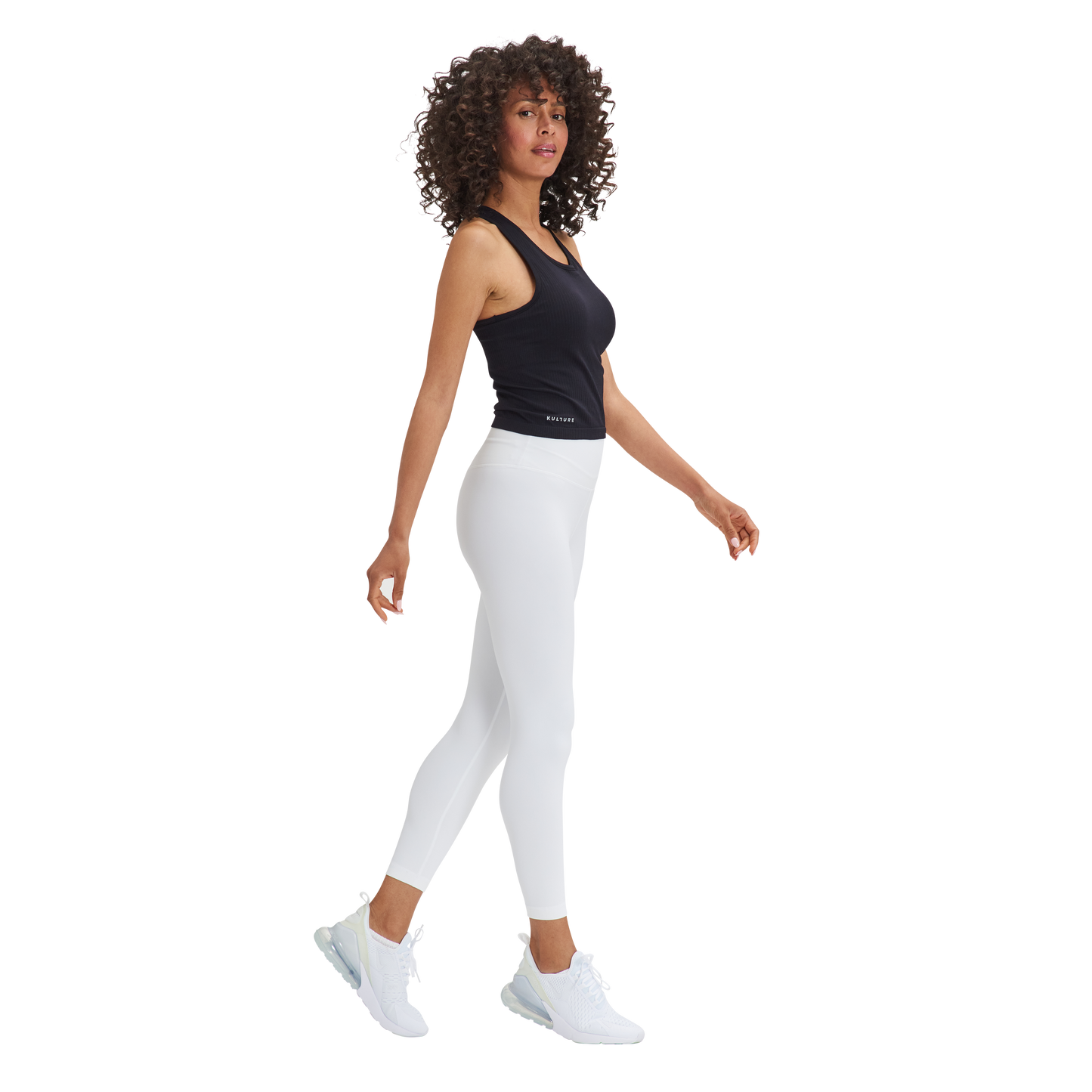 A woman in a Kulture Noho Seamless Built-In Bra Tank Top and white leggings.