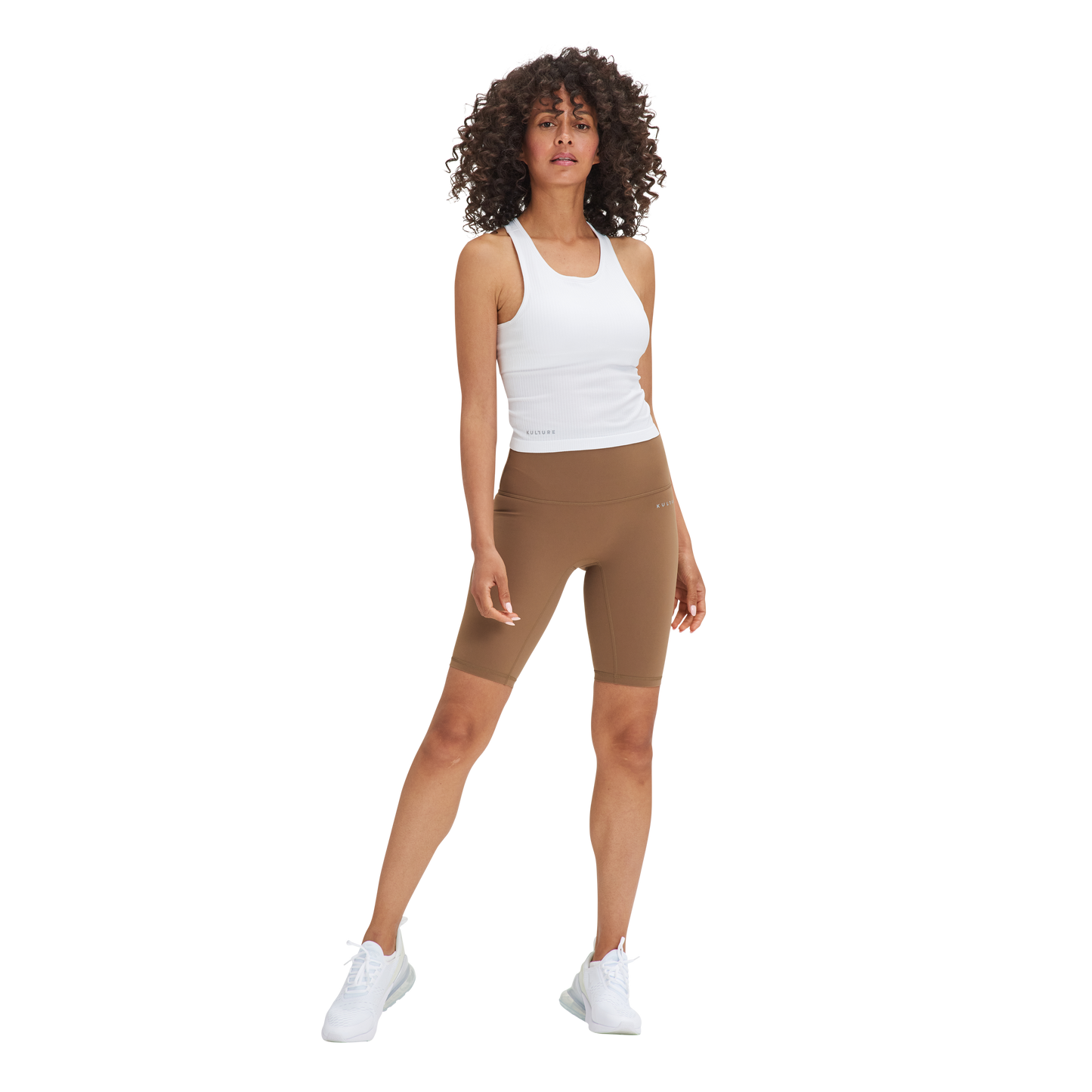 A woman in a Kulture Noho Seamless Built-In Bra Tank Top and brown shorts.