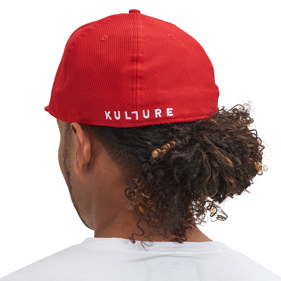 A man wearing a red Authentic Kollection 59FIFTY Fitted hat with the word Kulture on it.