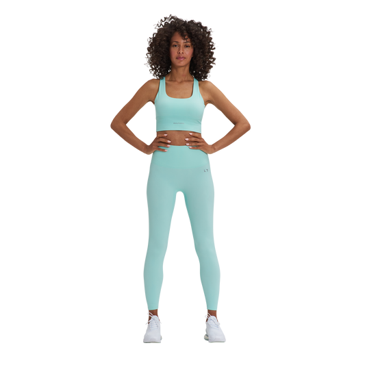 A woman in a blue Kulture sports bra top and Soho Sculpt leggings.