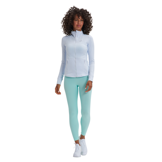 A woman in a white shirt and mint green Kulture Sunset Define Full-Zip Jacket with Pockets leggings.