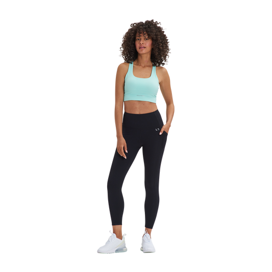 A woman in a Kulture Chelsea Leggings with Pockets and sports bra top.