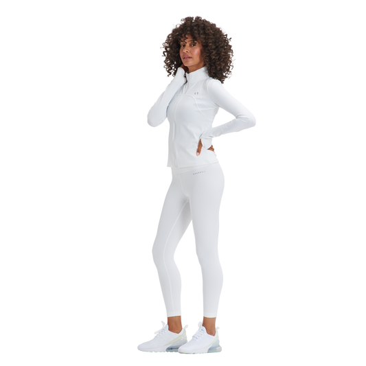 A woman in white Kulture Soho Sculpt Leggings is posing for a picture.