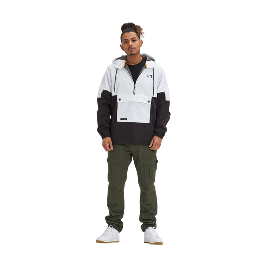 A man standing in front of a white background wearing a Kulture LAX V1 Hooded Anorak.