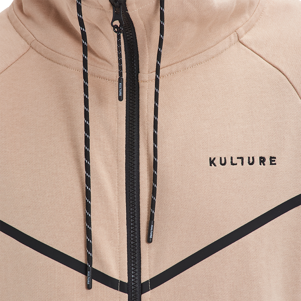 A close up of a person wearing Kulture's ATL Sand Full-Zip Hoodie & Joggers.