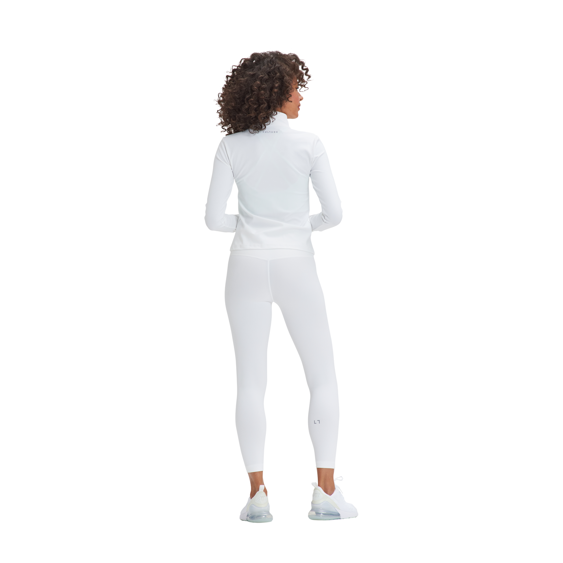 A woman in a white top and leggings wearing the Kulture Marina Sculpt Yoga Jacket.